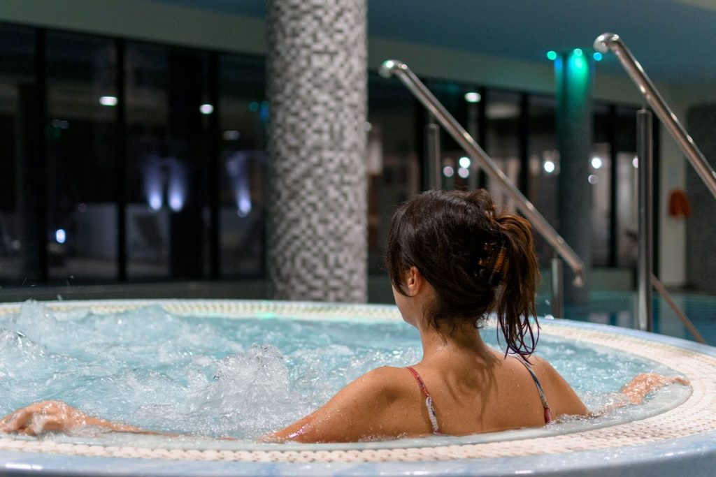 Rear view of woman in hot tub or whirlpool in spa