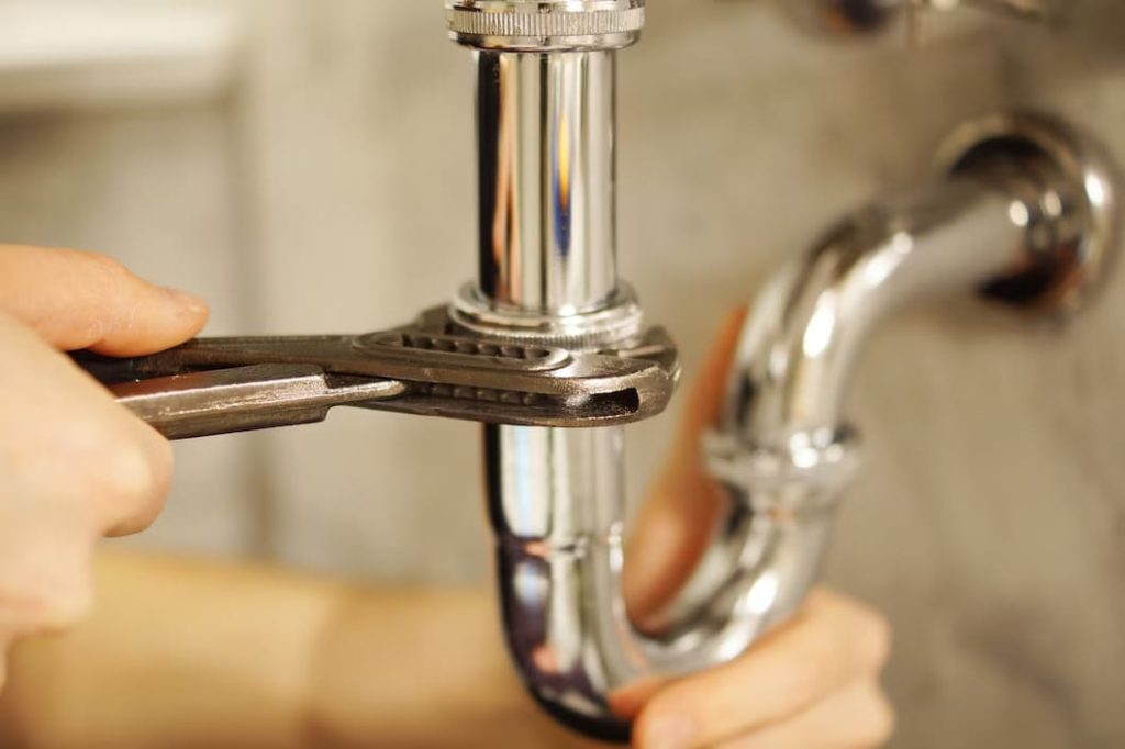 Use a bath socket wrench to remove a two-handle faucet stem